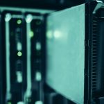 Fileiras de racks de servidores em um datacenter moderno, iluminadas por luzes azuis.