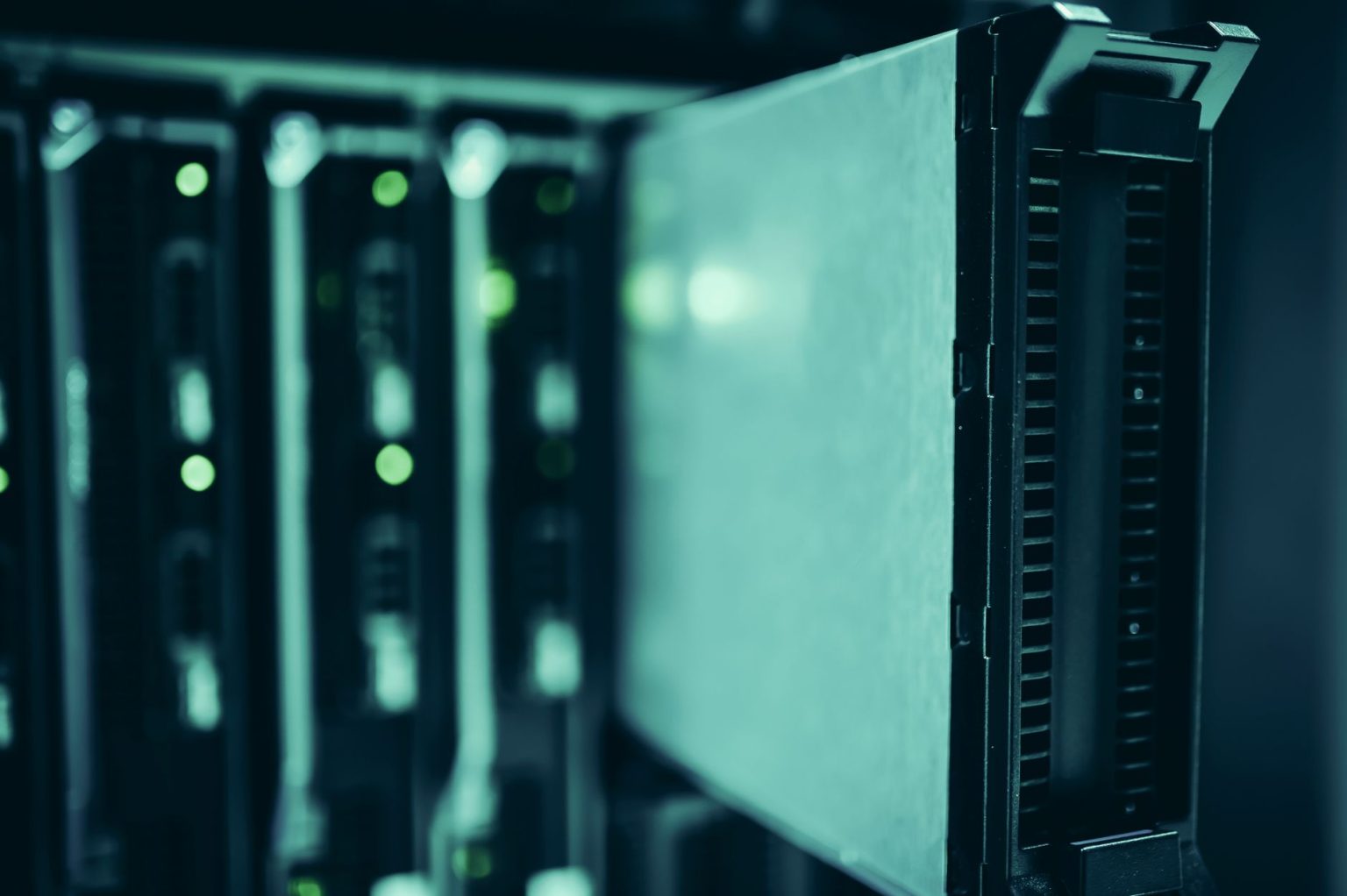 Fileiras de racks de servidores em um datacenter moderno, iluminadas por luzes azuis.