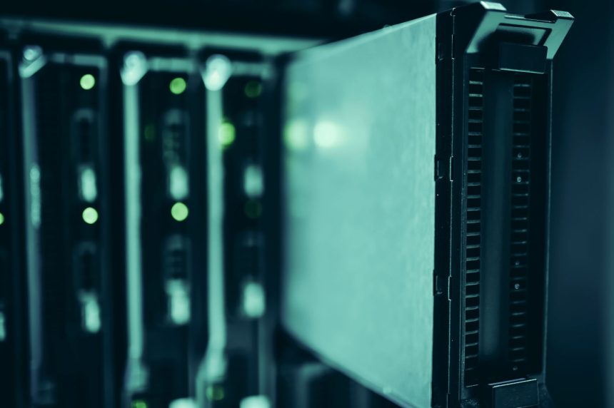Fileiras de racks de servidores em um datacenter moderno, iluminadas por luzes azuis.