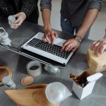 Equipe diversa colaborando em um projeto de inovação tecnológica em uma oficina, com ferramentas e protótipos sobre a mesa.
